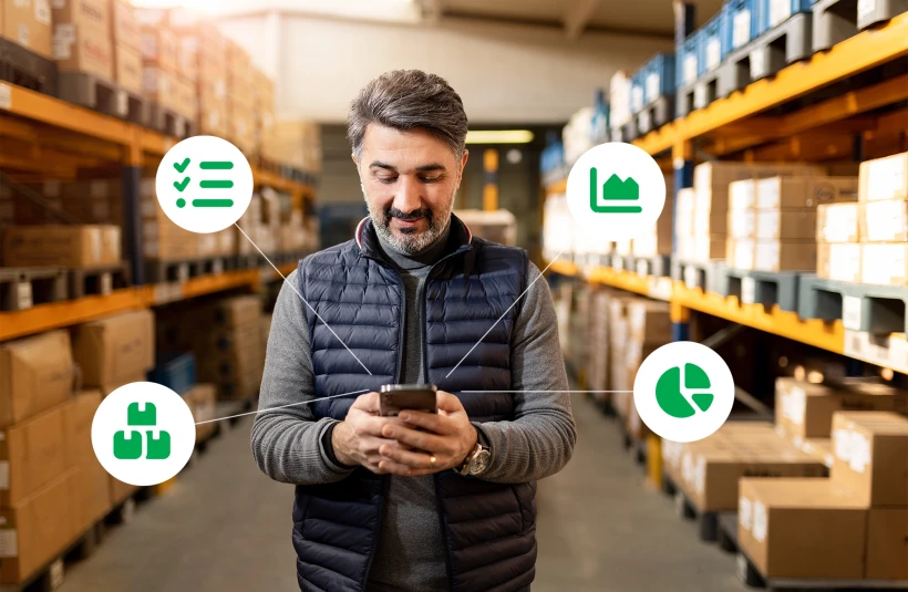 Man in a warehouse looking at a mobile phone